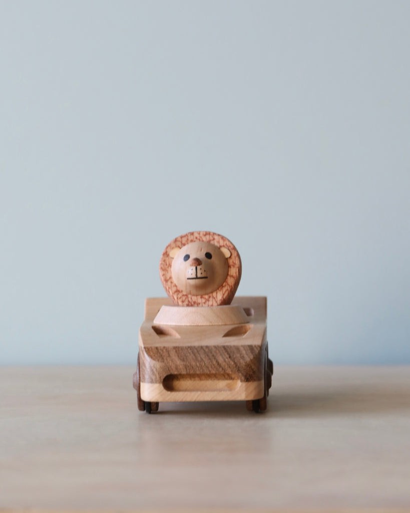 Wooden car toy with a lion as the driver.