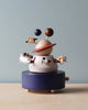 A whimsical Wooden Outer Space Music Box, featuring varied sphere planets orbiting around a larger, central circle, on a navy blue circular base against a soft beige background.