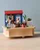 Miniature toy scene on a Wooden Fox Gardener Music Box featuring two bear figurines gardening by a small house with potted plants and a "my green garden" sign, crafted from sustainably sourced wood.