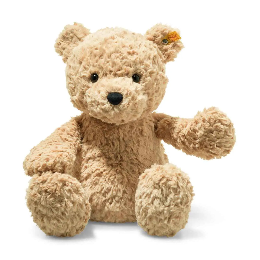 A Steiff, Jimmy Teddy Bear, 16 inches with a light brown, fuzzy texture, sitting upright and facing forward. The bear has black eyes, a small brown nose, and features a distinctive Button in Ear.
