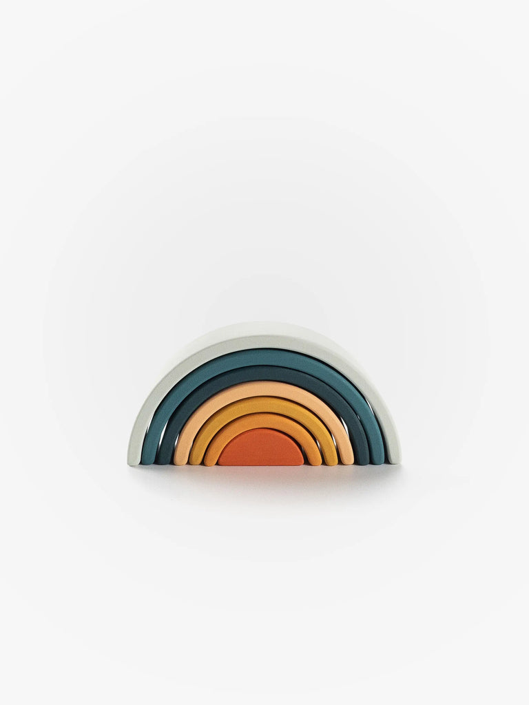 A stack of Handmade Mini Rainbow Stacker - Lagoon in shades of blue, gray, and orange arranged in a semicircular shape, resembling a rainbow, against a plain white background.