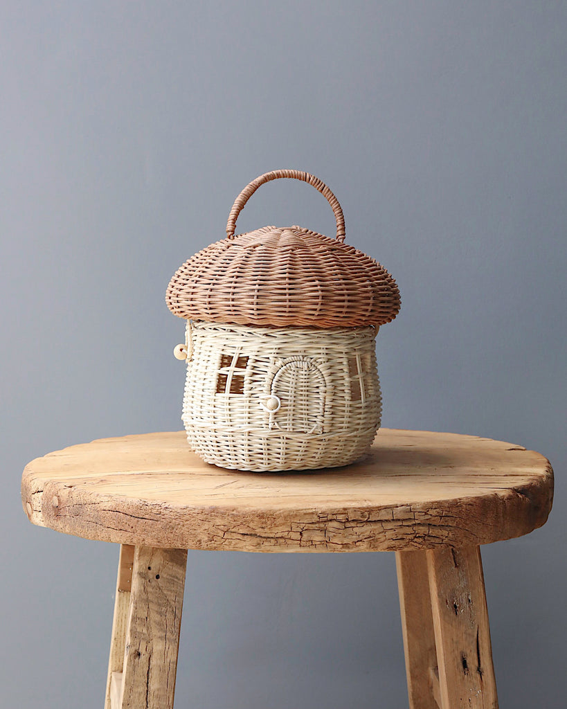 A natural color mushroom rattan basket on a chair.