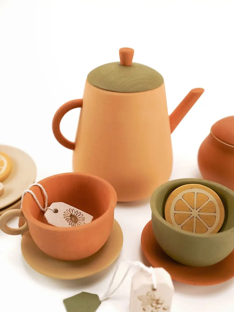 Handmade Wooden Tea Set - Herbal with a teapot, cups, and saucers in earth tones, featuring non-toxic paint and decorative details like a lemon slice and tea tags.