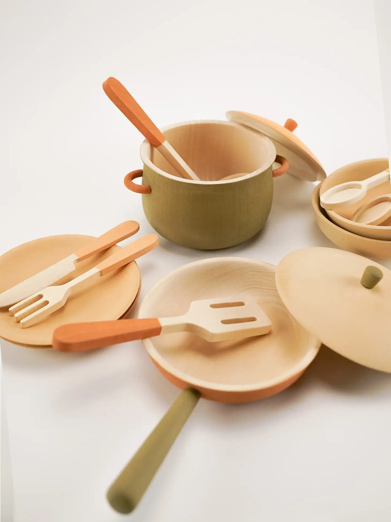 A set of eco-friendly, Herbal handmade kitchen toys, including plates, a pot with a lid, and utensils with wooden handles, displayed on a white background.