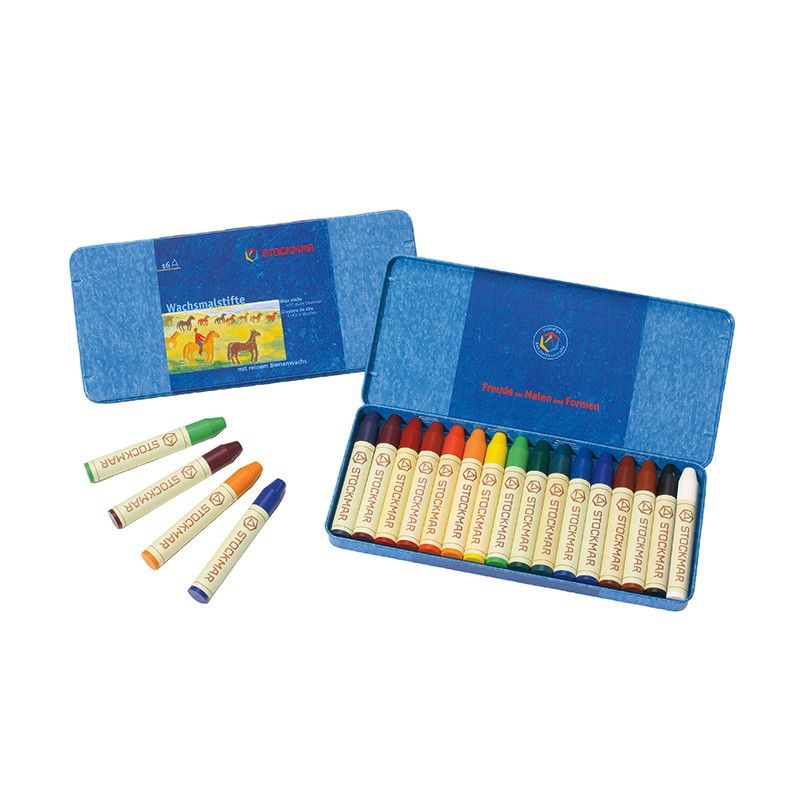 A set of colorful Stockmar Wax Stick Crayons in a tin case displayed in an open blue cardboard box alongside a closed box with an illustrated label showing a child engaging in art education.