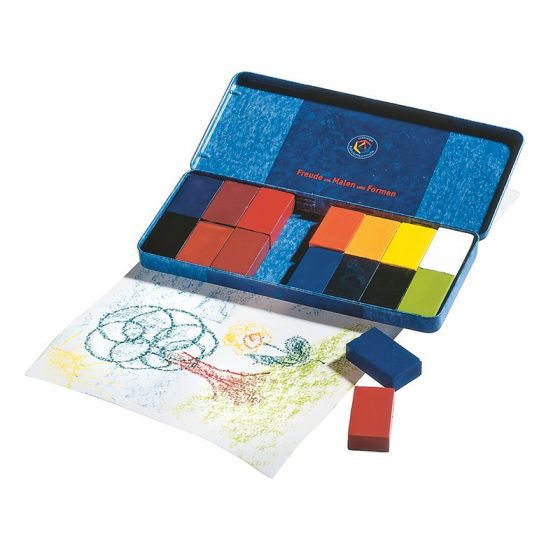 A set of colorful Stockmar Wax Block Crayons Tin Case - 16 Assorted in a blue storage tin, with a drawing of flowers shown beside it. Some crayons are placed on the drawing, and the tin lid features a logo.