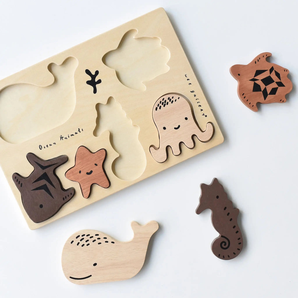 Wooden Tray Puzzle - Ocean Animals from the Ocean set for children with ocean animal shapes including a whale, starfish, turtle, octopus, and seahorse; some pieces removed and placed beside the puzzle board.