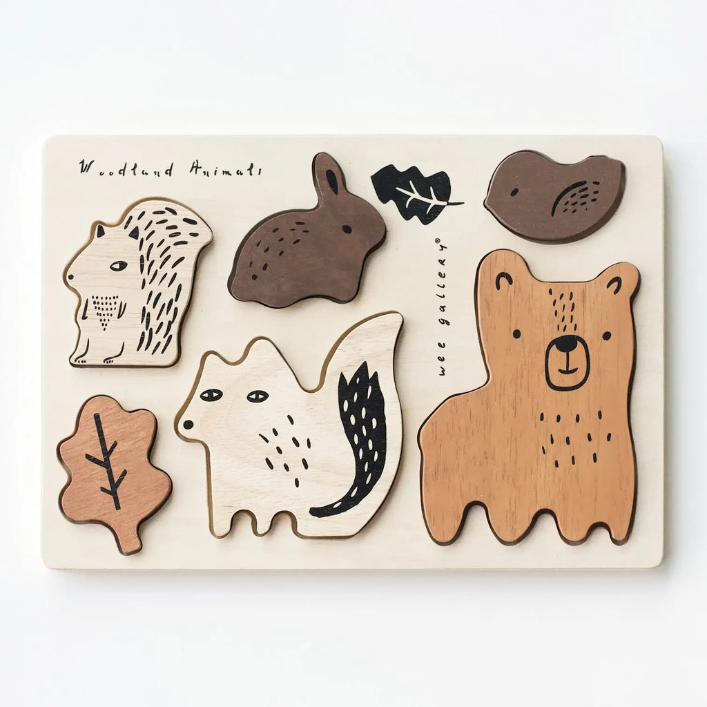 A Wooden Tray Puzzle - Woodland Animals from the Woodland set, featuring various woodland animal shapes such as a bear, hedgehog, fox, bird, and leaf, with simple line details and natural wood tones crafted from