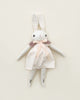 A Polka Dot Club Medium Cream Rabbit Hand Knit Collar with long ears and hand embroidered facial features, wearing a pink dress and a knit scarf, displayed against a light beige background.