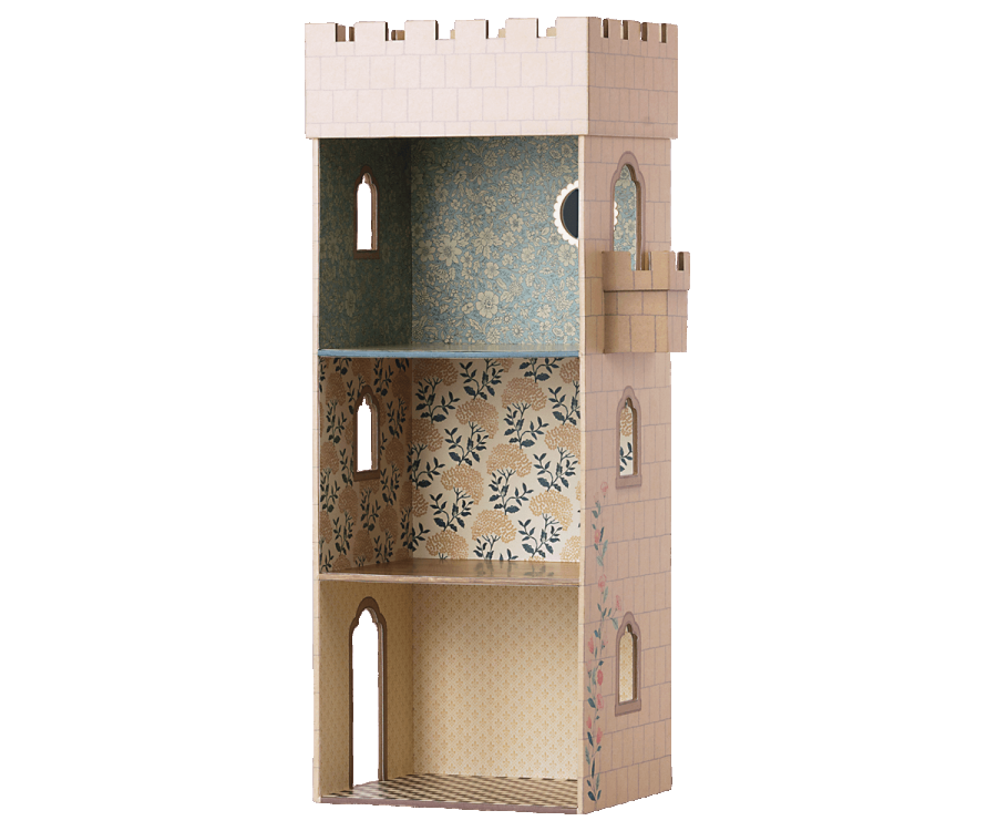 A Maileg Castle Tower designed as a castle tower. It has multiple floors decorated with patterned wallpapers, arched windows, and a small balcony on the right side. Made from sturdy cardboard, the exterior features a beige brick design with colored floral accents, making it a perfect castle for mice.