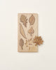A Wooden Leaf Puzzle with engravings of various leaf shapes including a maple and individual solid wood leaf cutouts beside it, all against a plain beige background.
