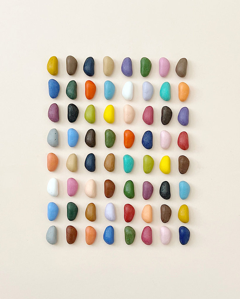 An array of colorful, Non-Toxic 64 Piece Crayon Rocks meticulously arranged in a grid pattern against a neutral background, featuring a wide range of colors including blues, greens, reds, and yellows