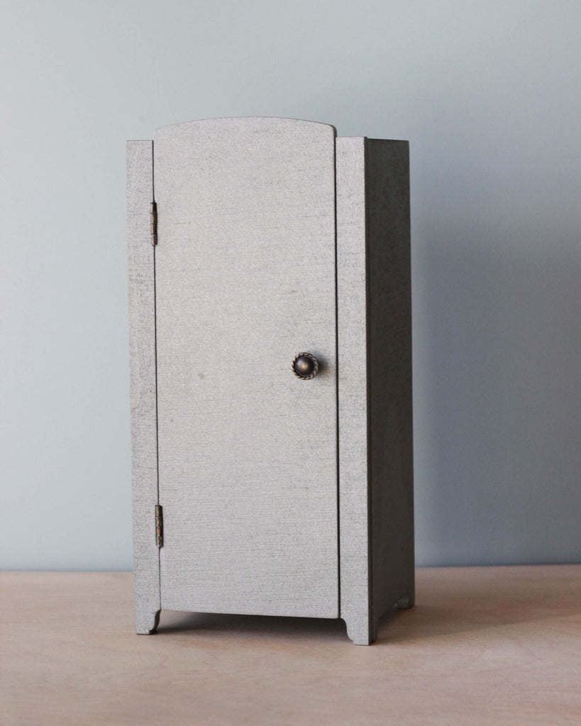 A small grey Maileg Miniature Closet with a knob.