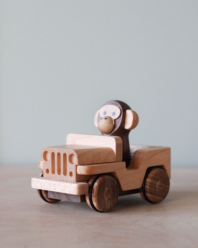 Wooden car toy with a monkey as the driver.