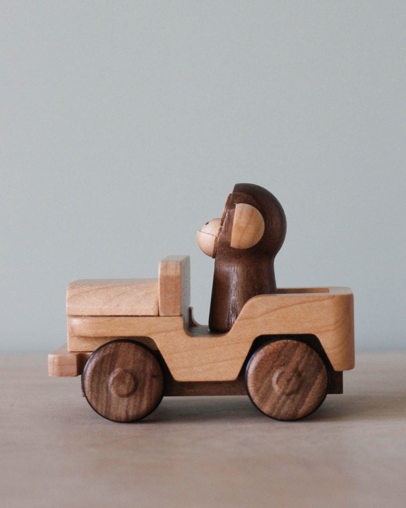 Wooden car toy with a monkey as the driver.