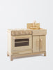 A sustainable Milton & Goose Wooden Play Kitchen - Made in USA featuring a stove, oven, and sink with knobs and doors, isolated on a white background.