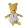 A Maileg Teddy Baby with a yellow head and limbs, wearing blue and white checkered overalls with a bee patch, sitting against a white background.
