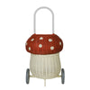 A whimsical Olli Ella Rattan Mushroom Luggy - Red on wheels designed to look like a mushroom, featuring a red top with white polka dots and a white base, complete with a sturdy handle.