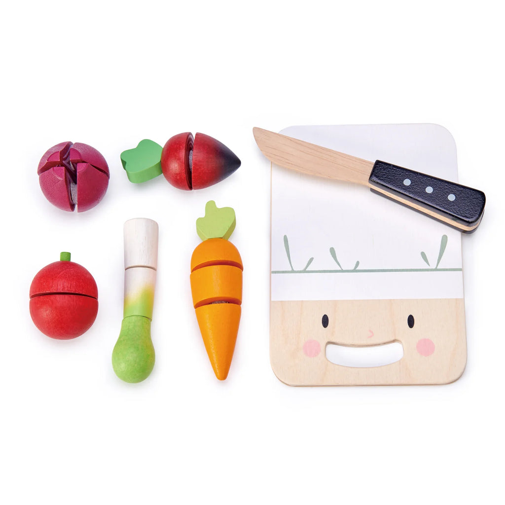 Children's Mini Chef Chopping Board play food set including a wooden chopping board with a smiling face, a knife, and various vegetables and fruits (apple, carrot, pear, radish) that can be chopped.