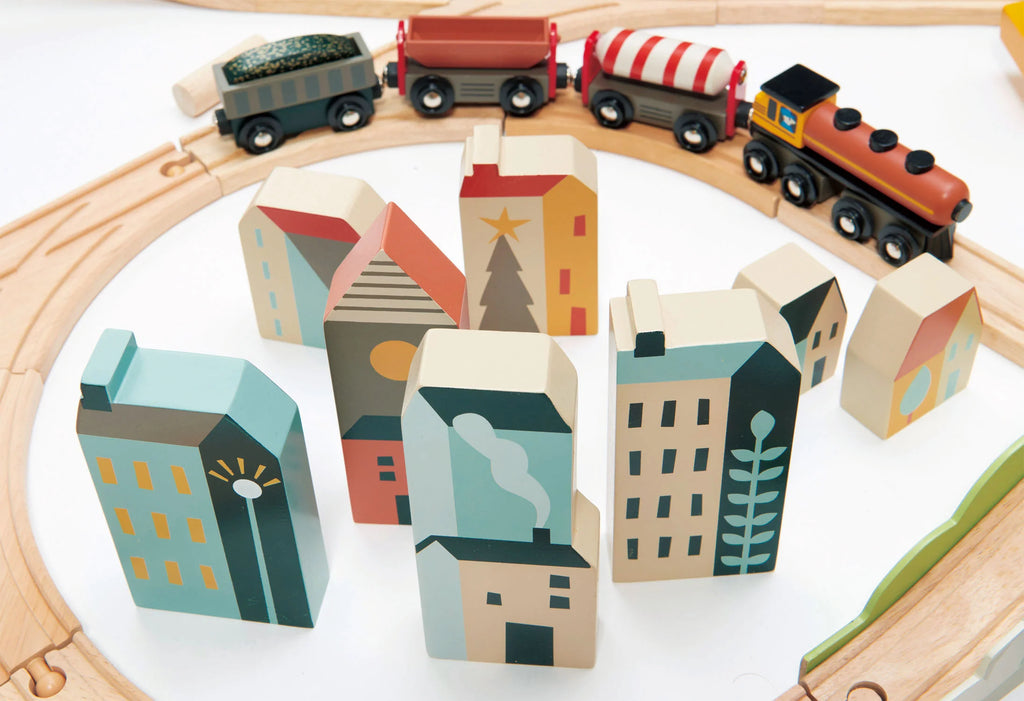 Colorful wooden Mountain View Train set cityscape with buildings and a modern train set, including a locomotive and various rail cars, arranged on a wooden surface.