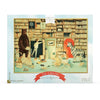 An illustrated jigsaw puzzle box depicting a whimsical library scene with a bear, a zebra, and children among strewn books and puzzle pieces, titled "The Library" by Emily Winfield Martin.