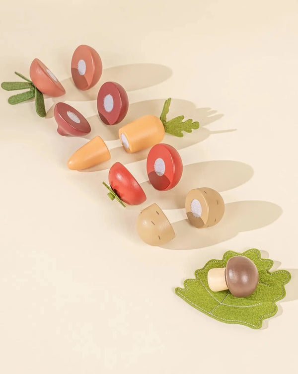 Sliceable wooden vegetable toys each divided in half with velcro in the middle. 