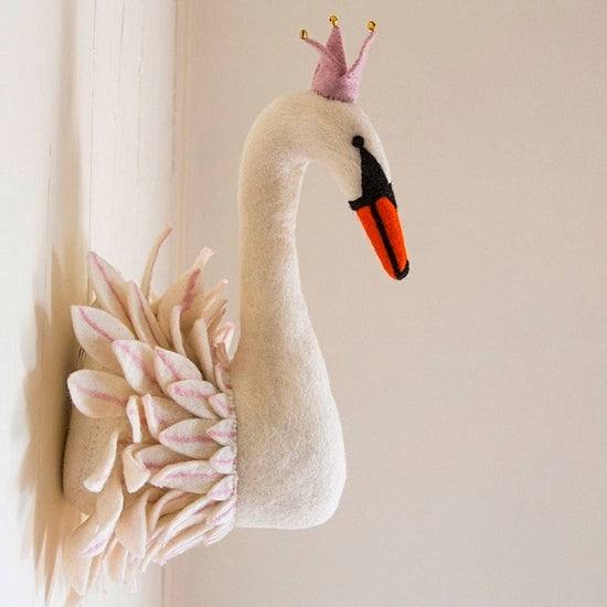 A decorative Handmade Felt Swan head mounted on a wall, featuring a crown with purple tips, an orange and black beak, and pink feathers on the side.