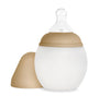 A BPA-free Medical Grade Silicone Baby Bottle with a measurement scale, featuring a removable tan cap and a clear nipple, isolated on a white background.