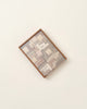 A Wooden Puzzle set, neatly arranged within a square frame on a light background, showcasing various puzzle pieces in shades of gray and brown. Please note this item is a choking hazard.