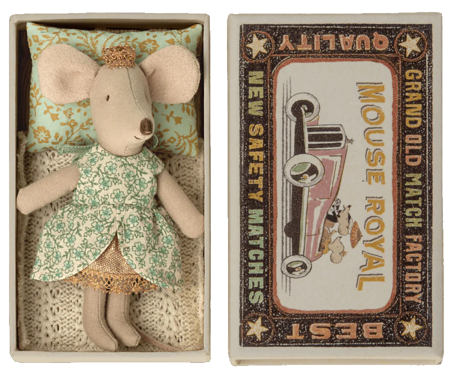 Maileg Princess Little Sister Mouse dressed in a green floral patterned attire and golden tiara, lying in a decorated matchbox that reads "grand old mouse royal match factory" with a vintage car design.