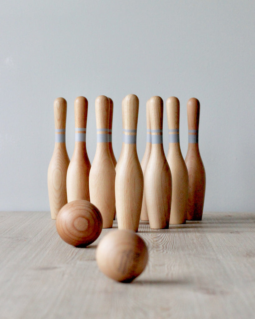 Wooden bowling pins and 2 wooden bowling balls.