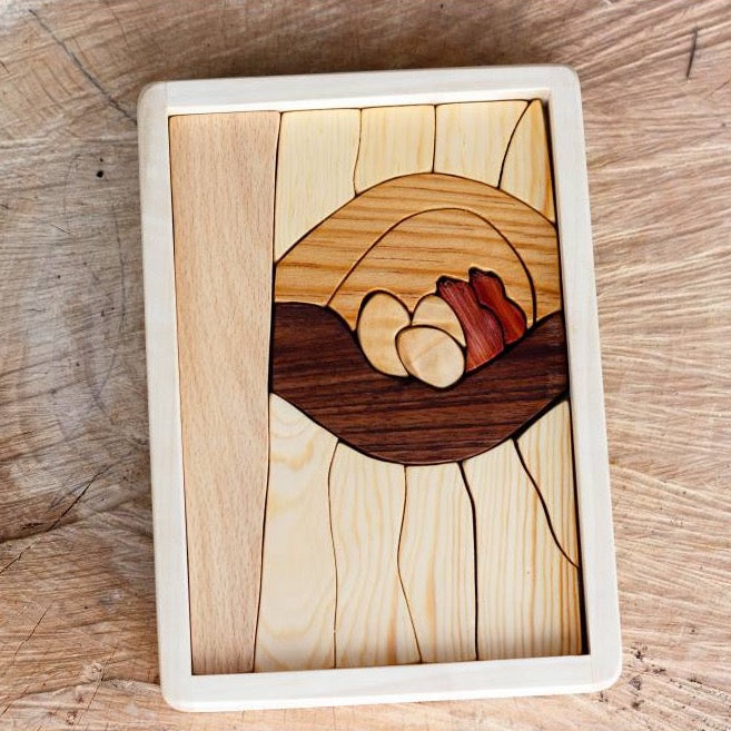 A Handmade Double Layer Wooden Puzzle - The Nest depicting a stylized sunset with ocean waves, crafted with multiple shades and grains of wood, featuring animal figures fitted into a rectangular tray.
