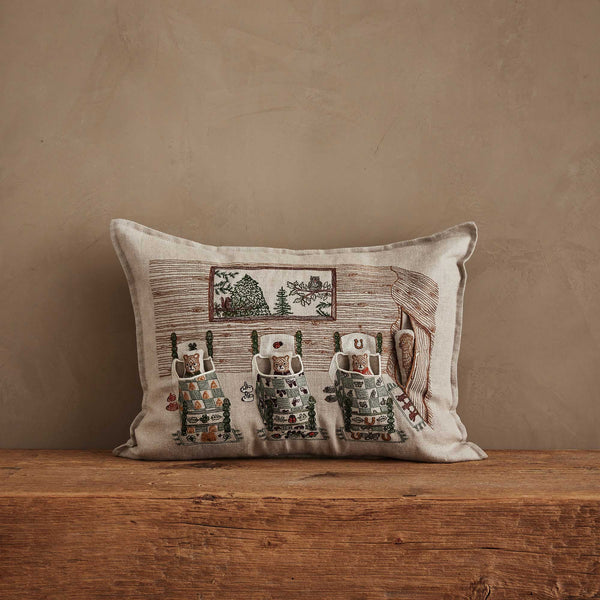 The Coral & Tusk Three Little Bears Pocket Pillow features embroidered bears in pajamas on beds, inspired by Goldilocks, set against a rustic room scene for a cozy, handmade touch. Ships in one week.