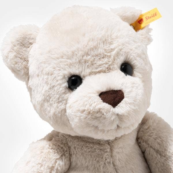 A close-up of the Steiff Robby Teddy Bear 17", a soft beige plush bear with dark eyes, a brown nose, and a yellow Steiff tag in its ear, shown against a light background.