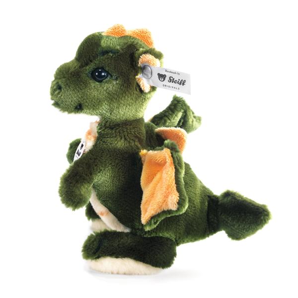 The Steiff Raudi Green Dragon Boy stands upright with soft wings, a tail, and the signature Steiff ear tag. Handmade with fuzzy green and orange material, this friendly dragon is a perfect collectible for any fan.
