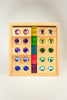 Wooden tray containing ten Bauspiel Gem Blocks with Pastel Lucent Cubes featuring circular colorful gems and a central column of six translucent square cubes.