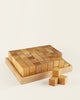 A set of Bauspiel Natural Corner Blocks, 24-Piece Set in a shallow tray, with three additional blocks arranged in a small stack nearby.