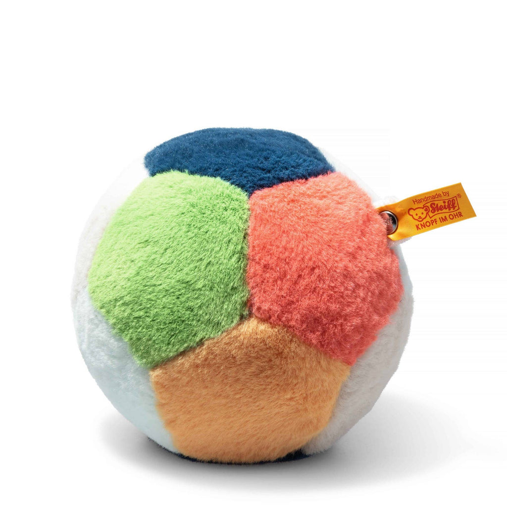 The Steiff Multicolored Plush Ball with Rattle features soft, fuzzy fabric segments in blue, green, orange, yellow, white, and peach. Easy to grip and from the Soft Cuddly Friends collection, it includes a yellow "Steiff" brand tag.