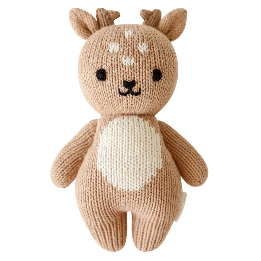 A hand-knit Cuddle + Kind Baby Fawn toy, crafted from soft Peruvian cotton yarn with white accents on its belly and face, featuring stitched eyes and a nose, and small antlers on top.