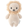 A Cuddle + Kind Baby Lion, hand-knit from Peruvian cotton yarn, with a soft beige body, fluffy mane, and sweet facial features including embroidered eyes and nose.