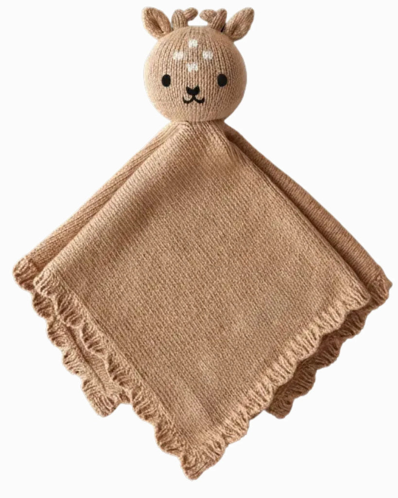The Cuddle + Kind Organic Cotton Baby Fawn Lovey is a light brown, heirloom-quality knitted blanket featuring a plush deer head with embroidered details, small antlers, and ruffled edges for extra charm.
