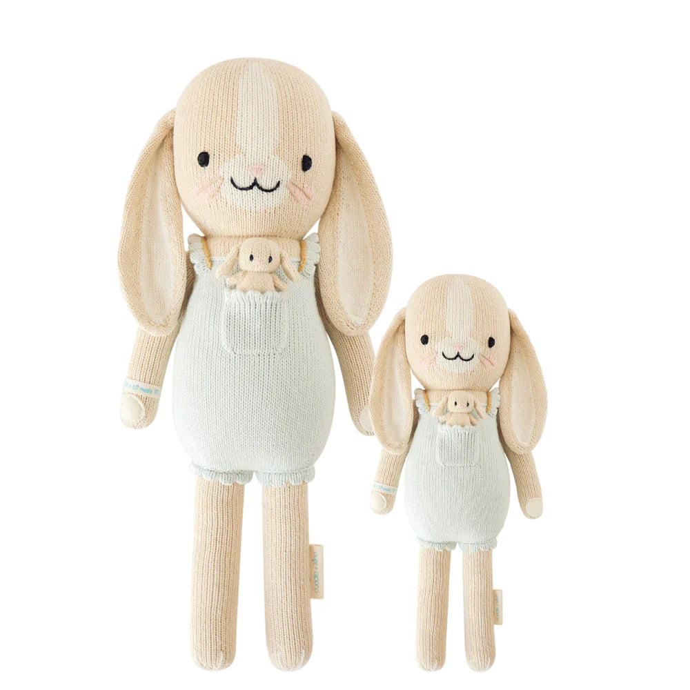 Two Cuddle + Kind Bunny toys with long ears, hand knit and stuffed with hypoallergenic polyfill, one large and one small, both in white overalls, isolated on a white background.