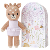 Cuddle + Kind Tiny Violet The Fawn toy standing next to a floral illustrated packaging with the name "Tiny Violet the fawn." The toy is beige and white, wearing a knitted dress, and the box features delicate