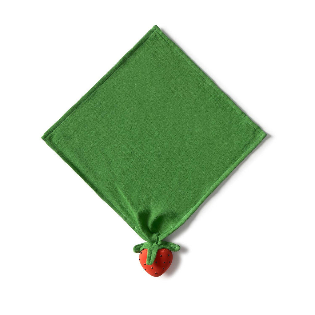 Sweetie the Strawberry Big Doudou is a green organic cotton cloth napkin styled in a diamond, with a red natural rubber strawberry corner and green leaves—ideal as a baby comfort or teething toy. Background is white.