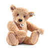 The Steiff Elmar Teddy Bear, 16", is a plush brown bear with soft fur, black button eyes, stitched nose, beige paw pads, Steiff's signature Button in Ear, and a "Steiff" chest tag. This handmade bear sits upright.