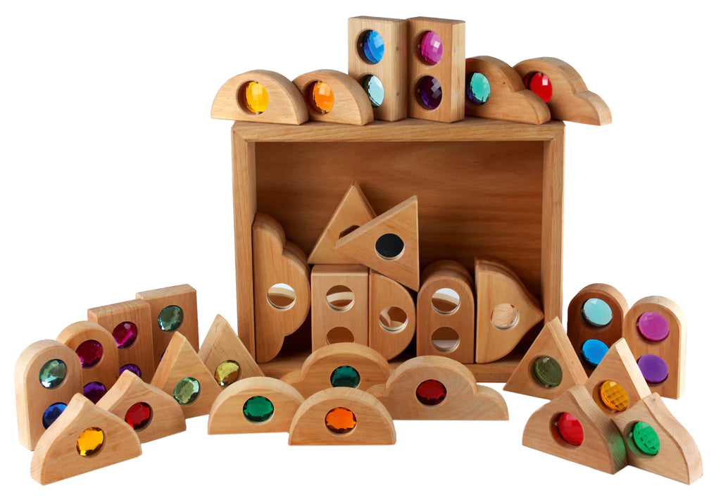 A variety of Bauspiel Fairytale Mixed Gemstone Sets with Tray, including blocks with colored gems and geometric shapes, creatively arranged against a white background.