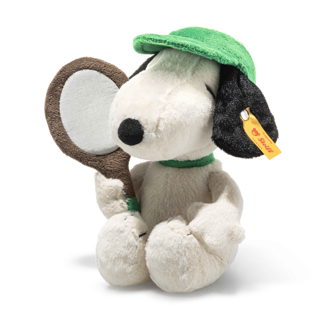 The Steiff Snoopy Tennis Player is a plush toy featuring Snoopy in a green visor and collar, holding a brown tennis racket with a yellow Steiff tag—an ideal collectible for Steiff enthusiasts and Peanuts fans alike.