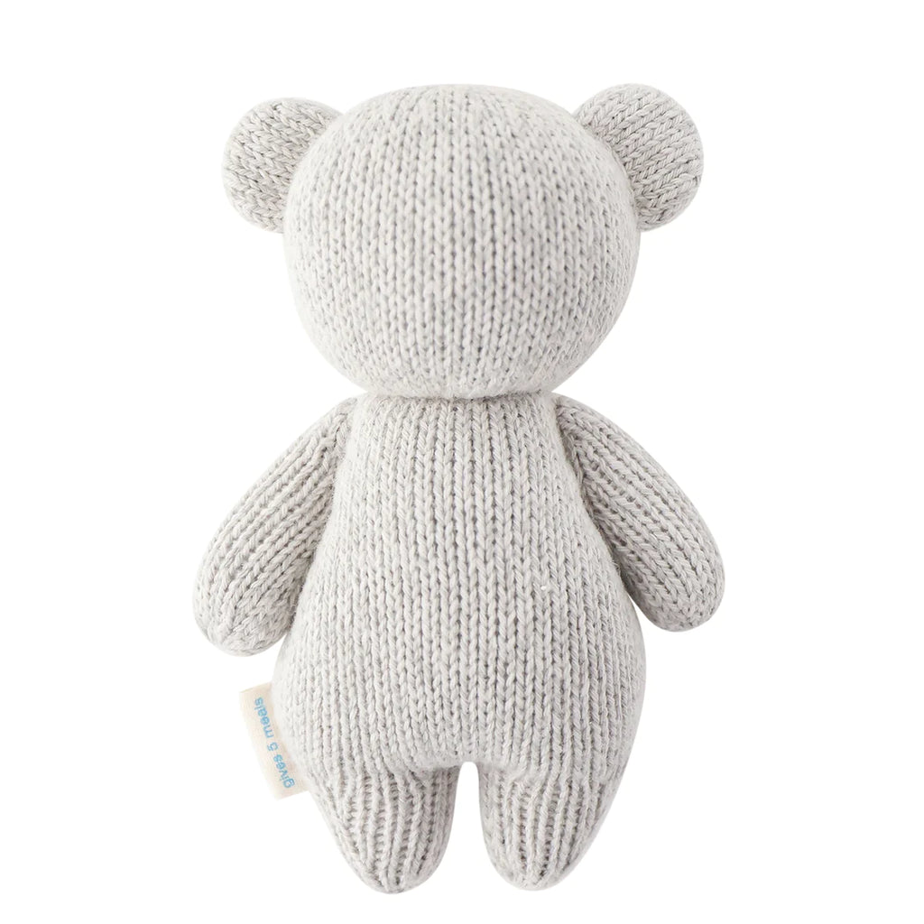 A Cuddle + Kind Baby Koala in a light grey color, shown from the back, featuring a simple and minimalist design with no face details, standing upright against a white background.