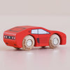 A small red wooden racing car, No. 25 GT140 Marco made in England, featuring white wheels, black accents, and minimalist printed windows, viewed from the rear against a light background.