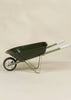 The Heritage Wheelbarrow – Liane, a green children’s wheelbarrow with white-handled grips and a single black and white wheel, ideal as a kids’ garden tool, is displayed on a neutral beige background.